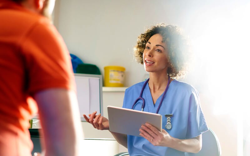 Healthcare professional uses tablet computer to discuss patient health profile