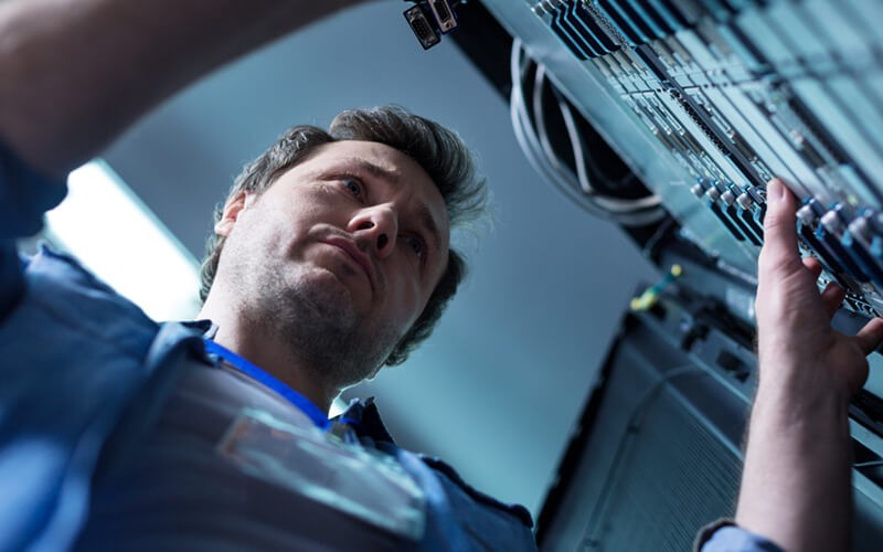 IT technician works on server rack in data center