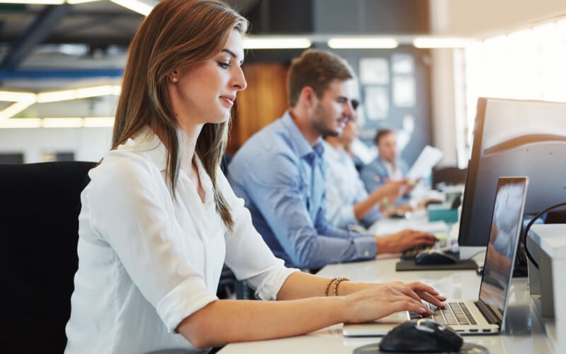 Businesswoman on laptop device in open office
