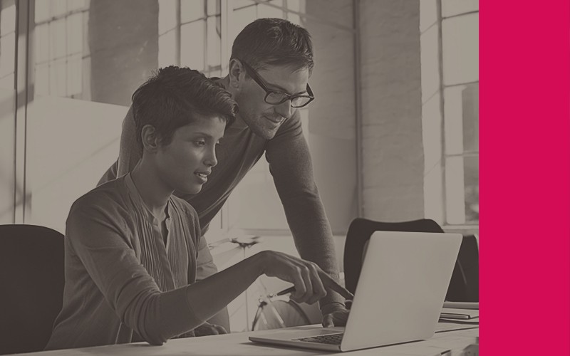 Two colleagues view procurement platform on desktop computer