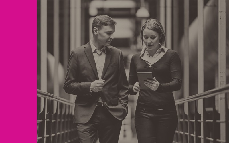 Man and woman walking down data center hallway with tablet