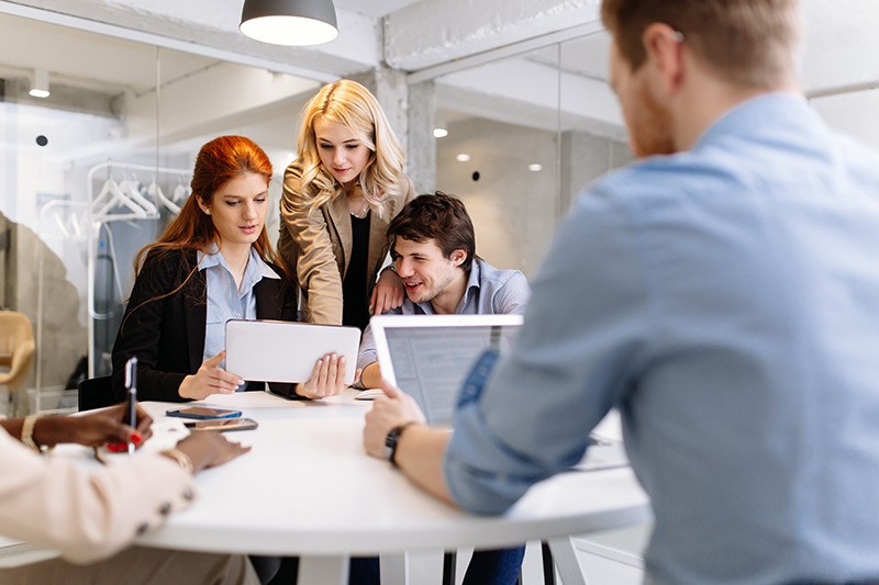 Business professionals brainstorming ideas with various mobile technology in hand
