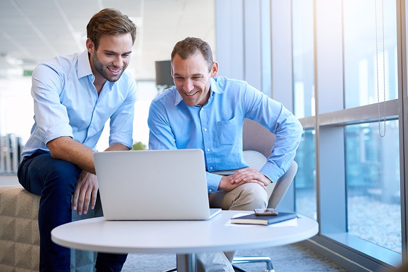 Business professionals working together on laptop computer