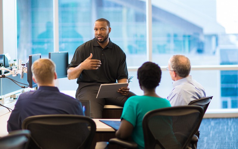 IT technician leading team in a conversation during meeting